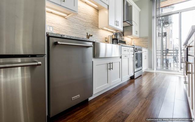 Undisclosed Address Chicago, IL 60607 - Photo 7 of 16 a kitchen with white cabinets and wooden floor