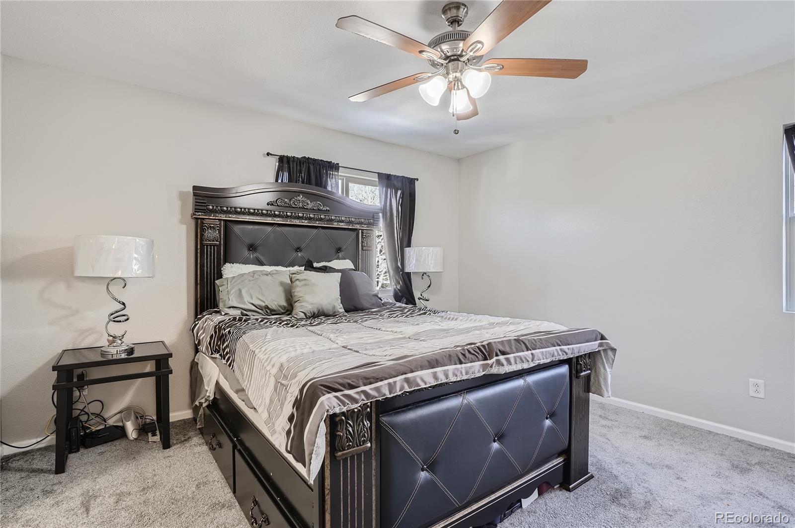 4725 Andes Street Denver, CO 80249 - Photo 11 of 27 a bedroom with a bed and a chandelier