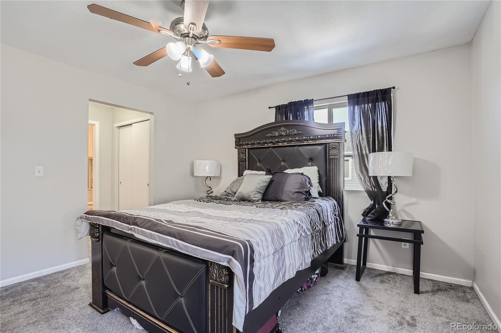 4725 Andes Street Denver, CO 80249 - Photo 12 of 27 a bedroom with a bed and a chandelier