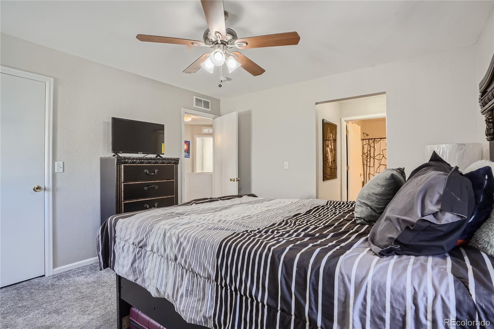 4725 Andes Street Denver, CO 80249 - Photo 13 of 27 a bedroom with a bed and tv