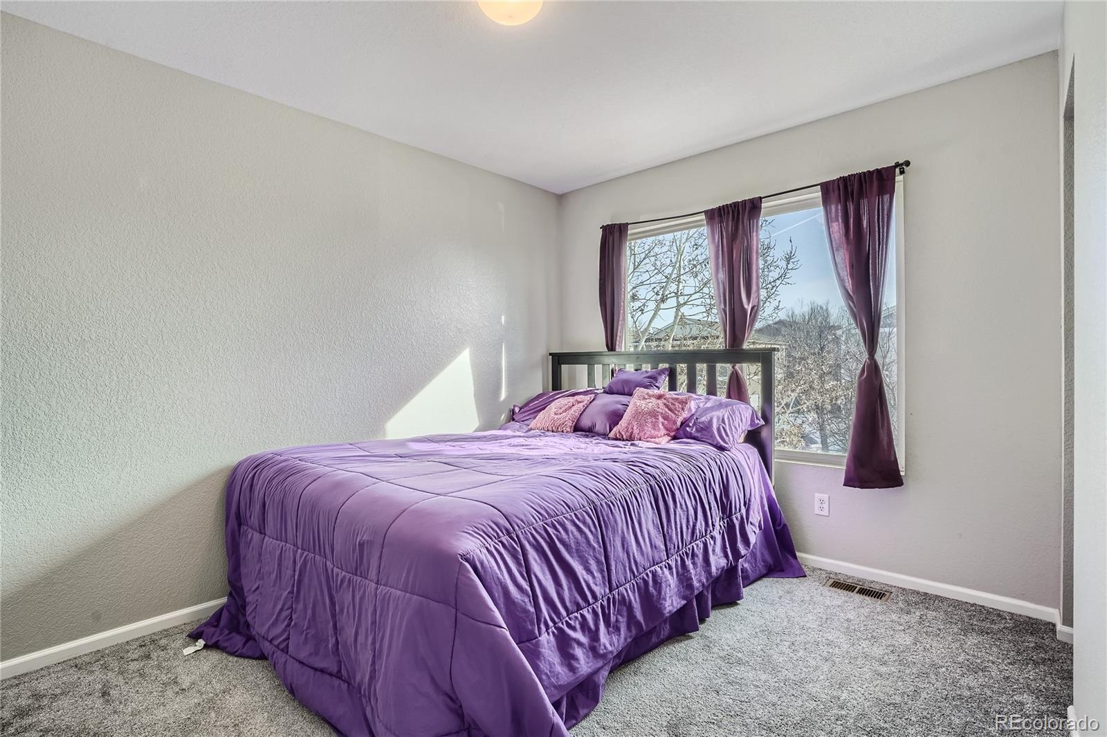 4725 Andes Street Denver, CO 80249 - Photo 16 of 27 a bed sitting in a bedroom next to a window