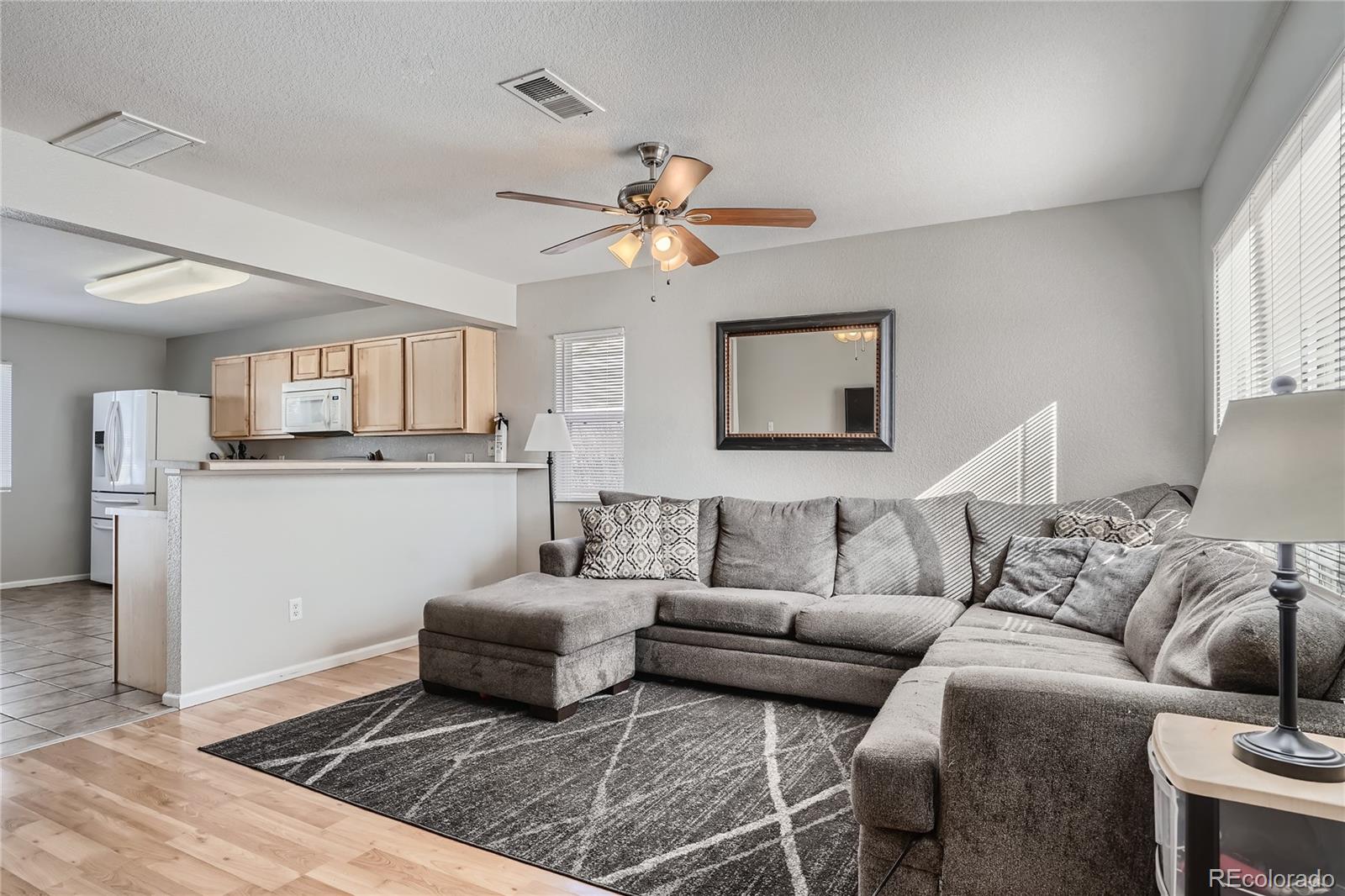 4725 Andes Street Denver, CO 80249 - Photo 4 of 27 a living room with furniture and a chandelier