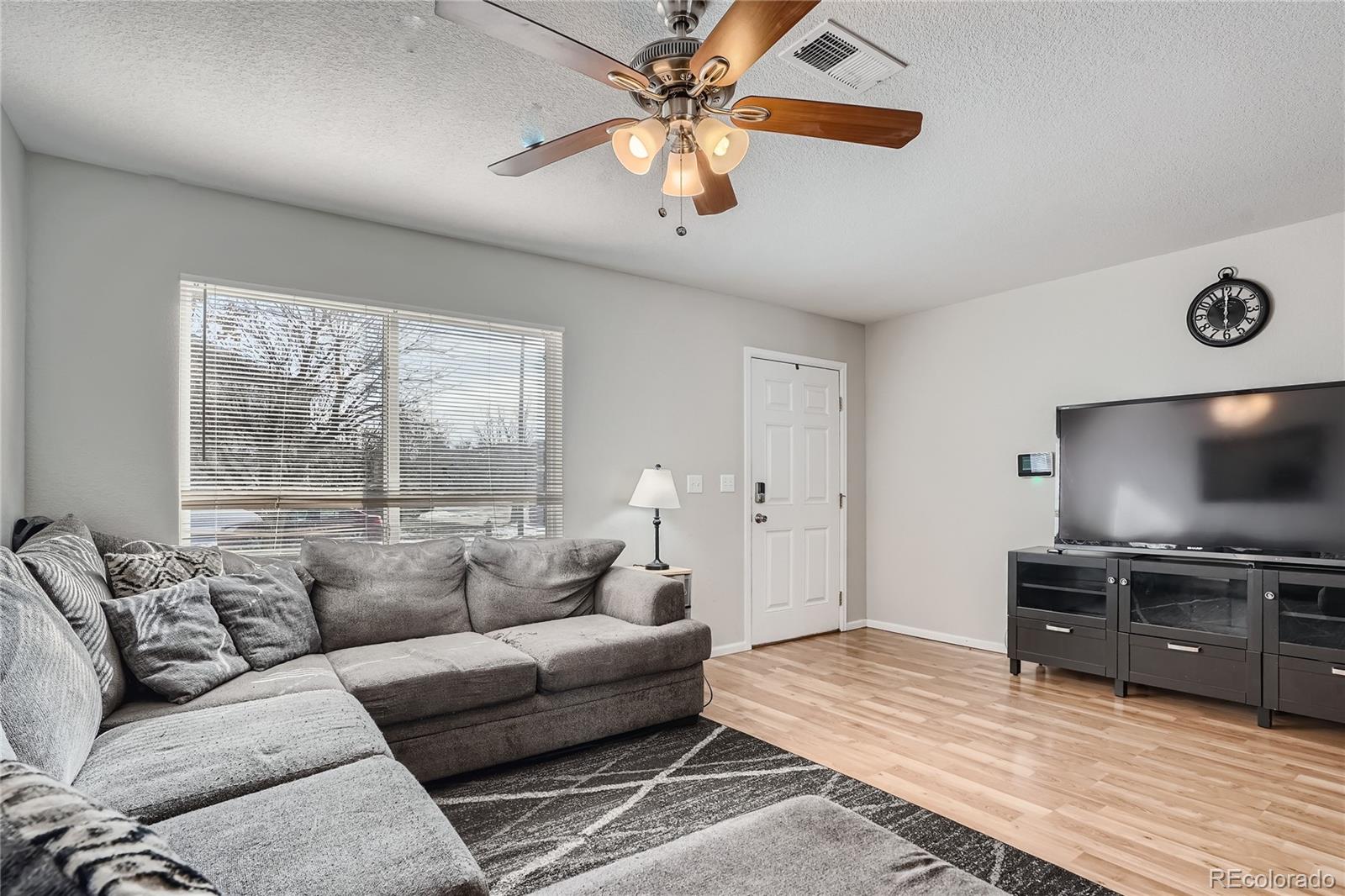 4725 Andes Street Denver, CO 80249 - Photo 6 of 27 a living room with furniture and a flat screen tv