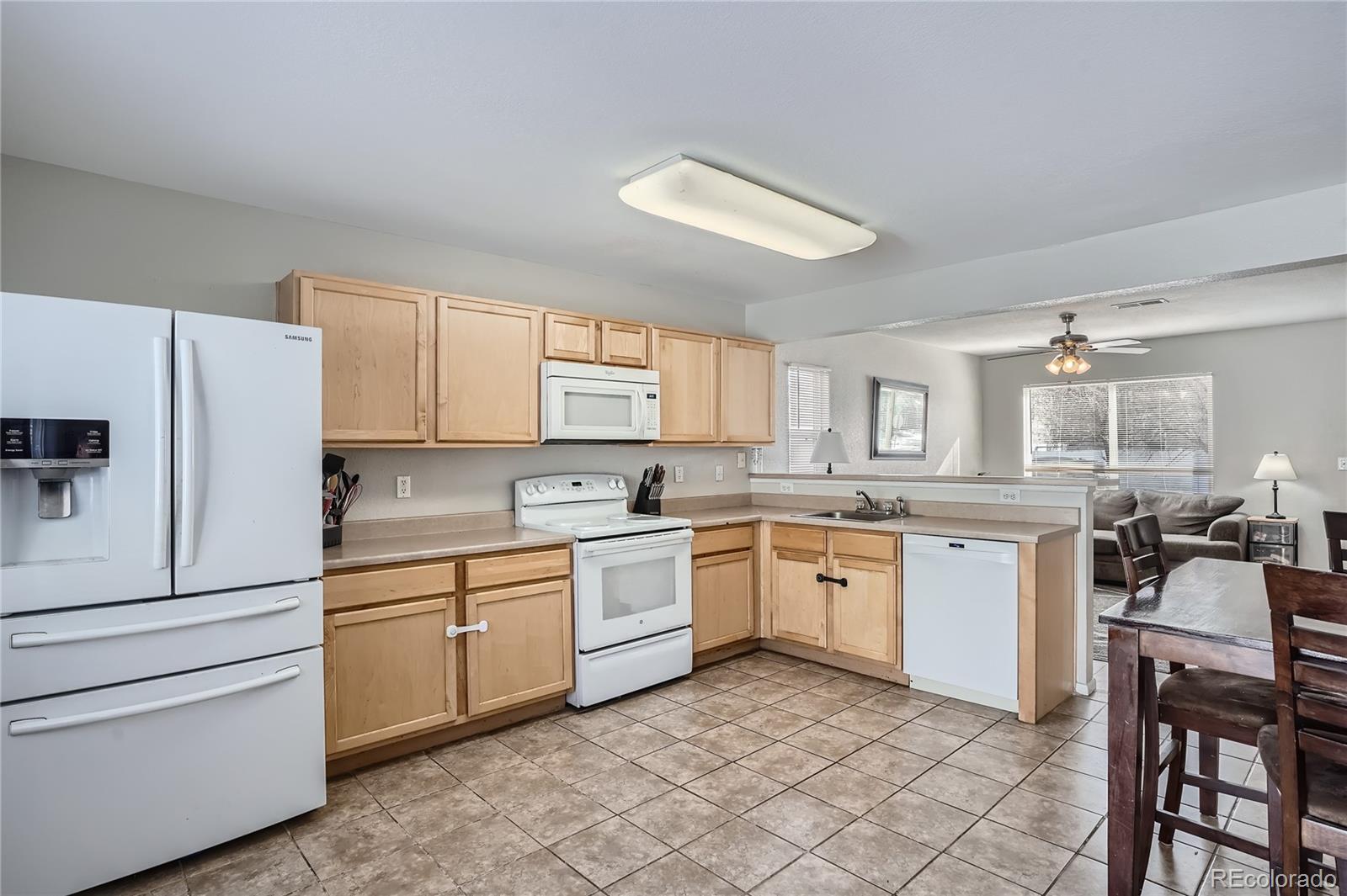 4725 Andes Street Denver, CO 80249 - Photo 9 of 27 a kitchen with white cabinets and white appliances