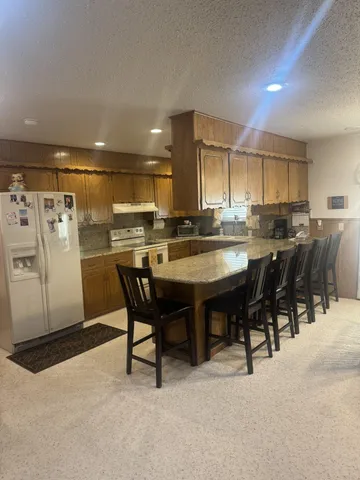 a kitchen with stainless steel appliances a table and chairs