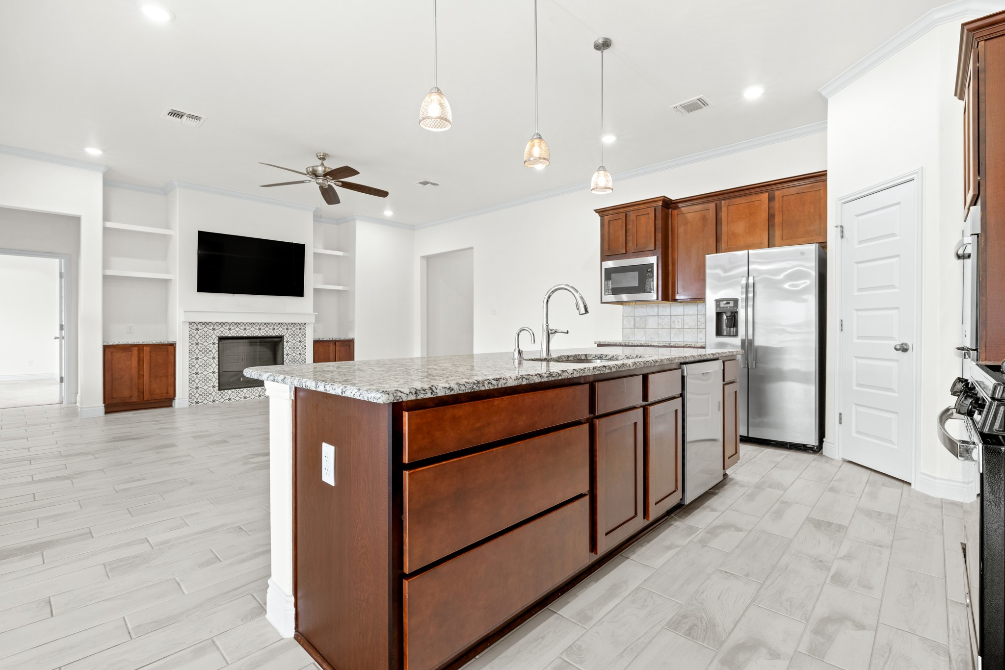 6019 Monza Drive Temple, TX 76502 - Photo 14 of 40 Kitchen with a kitchen island with sink, a ceiling fan, built in shelves, light stone counters, and stainless steel appliances