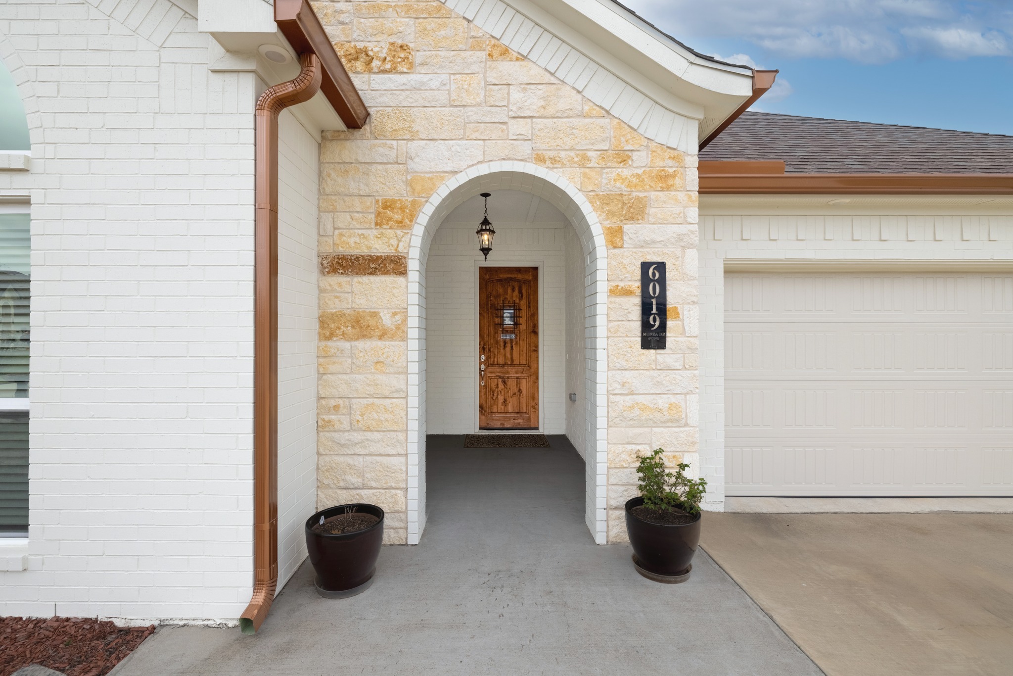 6019 Monza Drive Temple, TX 76502 - Photo 3 of 40 Property entrance featuring stone siding, a garage, concrete driveway, and a shingled roof