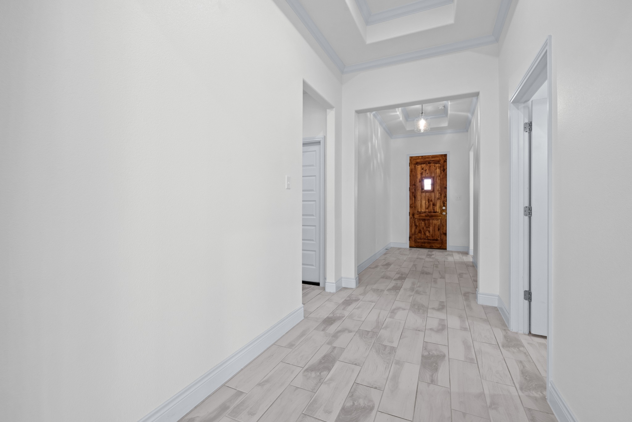 6019 Monza Drive Temple, TX 76502 - Photo 5 of 40 Corridor with ornamental molding, wood finish floors, and a raised ceiling