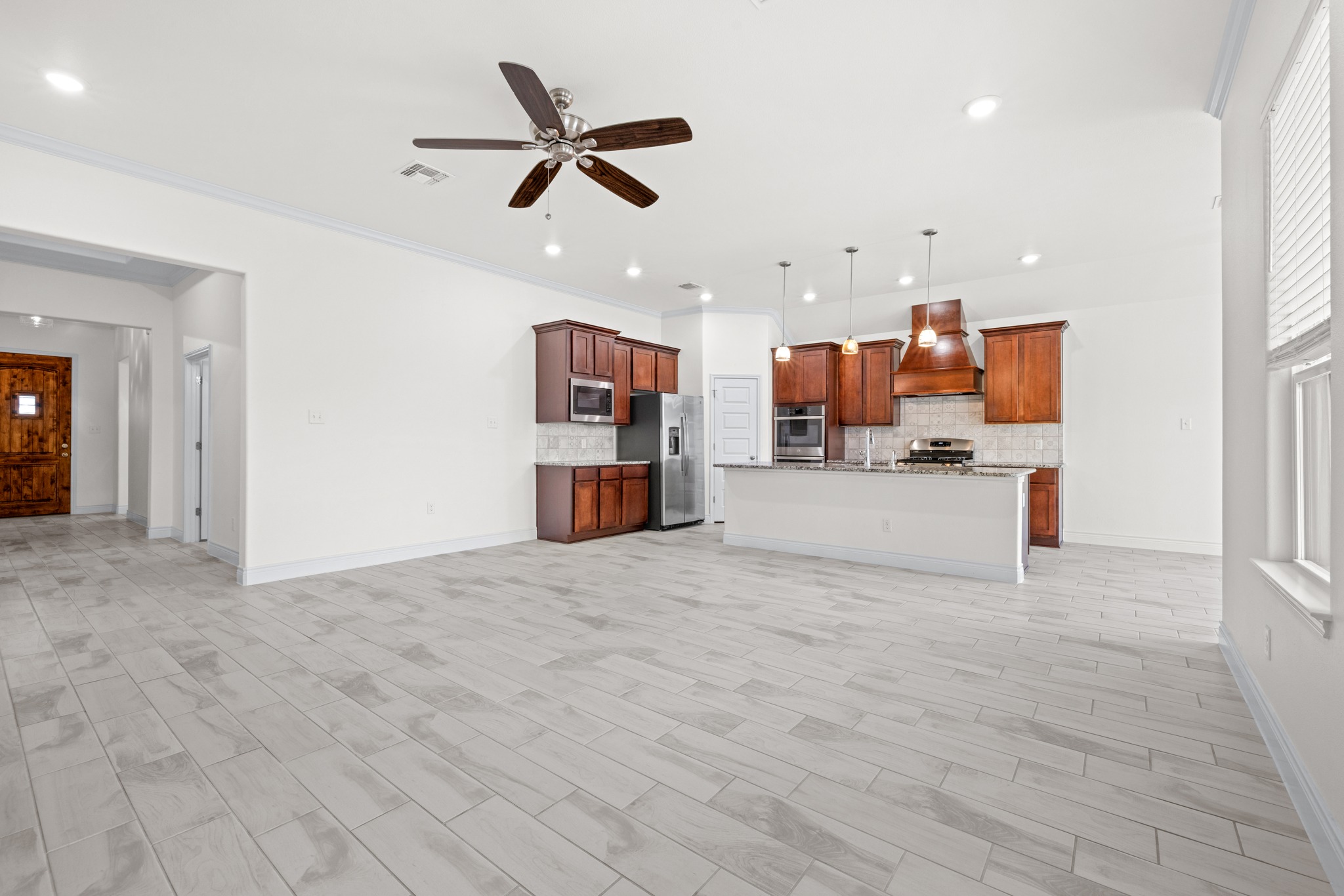 6019 Monza Drive Temple, TX 76502 - Photo 6 of 40 Unfurnished living room featuring ceiling fan, recessed lighting, ornamental molding, and wood tiled floors