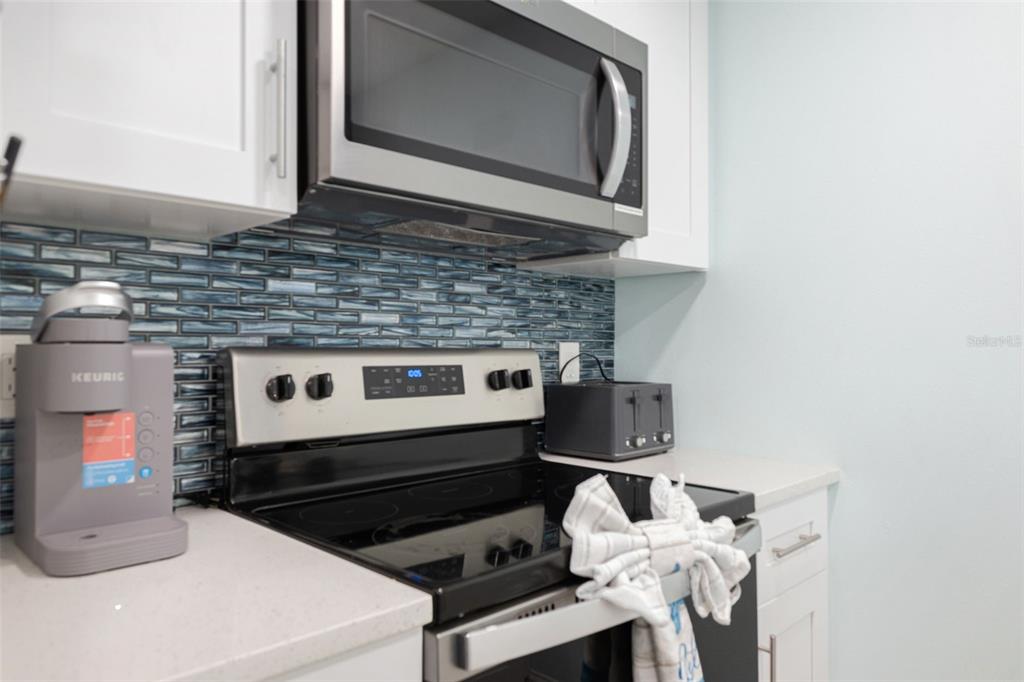 337 Rex Place, Unit G Madeira Beach, FL 33708 - Photo 11 of 40 a kitchen with a stove and a microwave