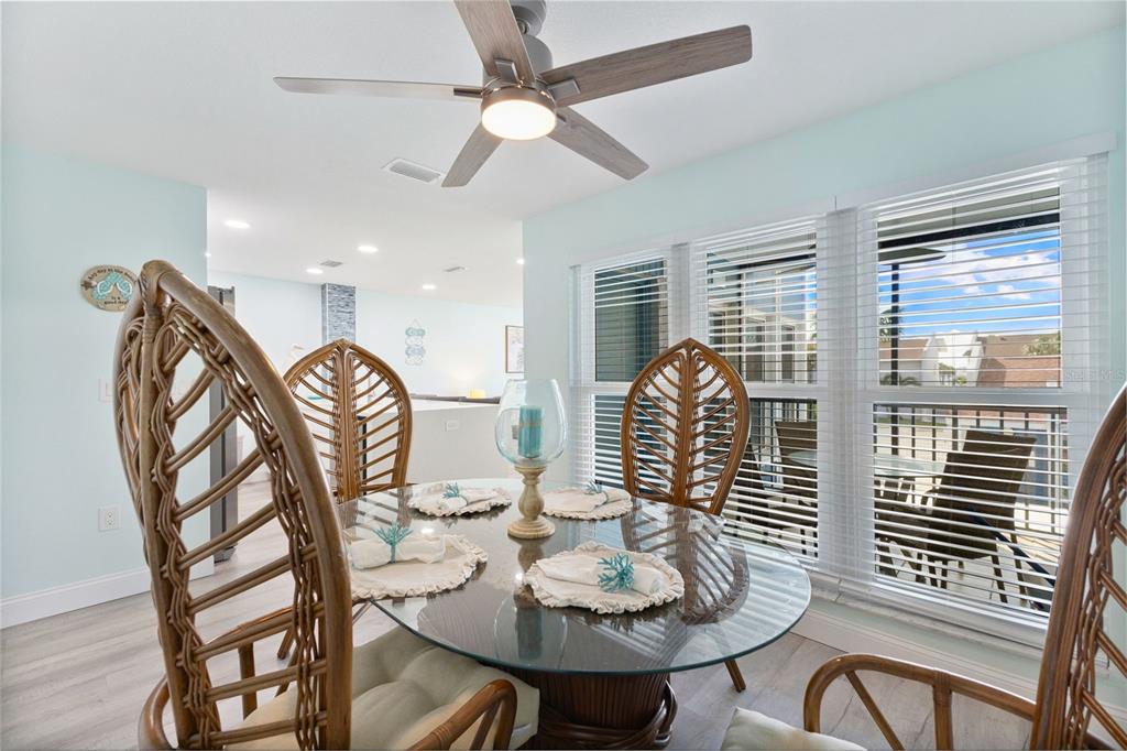337 Rex Place, Unit G Madeira Beach, FL 33708 - Photo 18 of 40 a dining room with furniture a chandelier and wooden floor