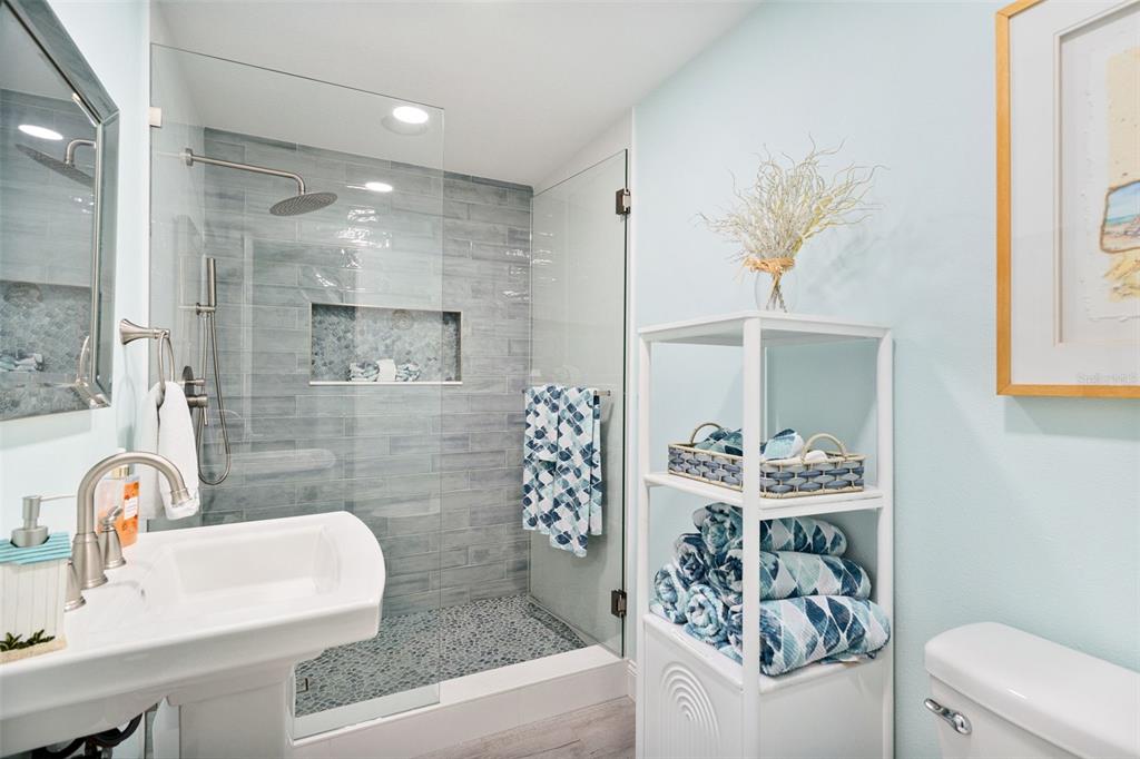 337 Rex Place, Unit G Madeira Beach, FL 33708 - Photo 19 of 40 a bathroom with a sink a toilet and a mirror