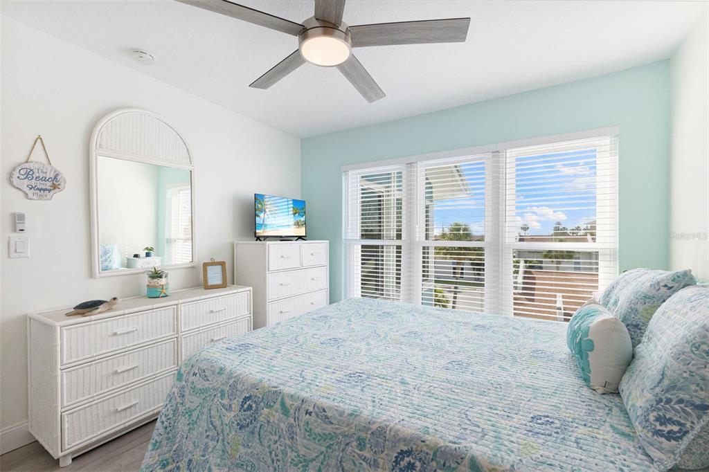 337 Rex Place, Unit G Madeira Beach, FL 33708 - Photo 21 of 40 a spacious bedroom with a large bed and a window