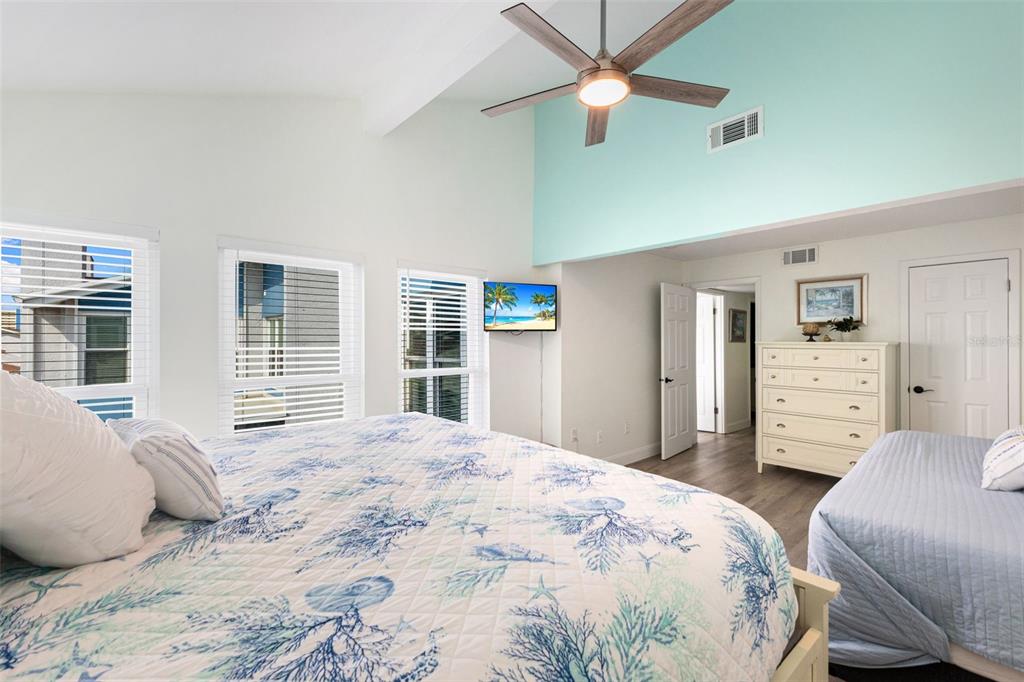 337 Rex Place, Unit G Madeira Beach, FL 33708 - Photo 25 of 40 a bedroom with a large bed and a chandelier