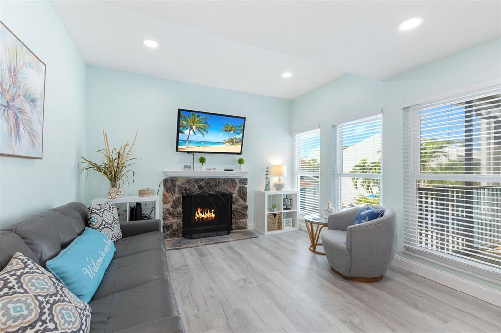 337 Rex Place, Unit G Madeira Beach, FL 33708 - Photo 5 of 40 a living room with furniture and a fireplace