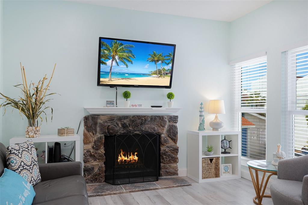 337 Rex Place, Unit G Madeira Beach, FL 33708 - Photo 6 of 40 a living room with furniture a fireplace and a large window