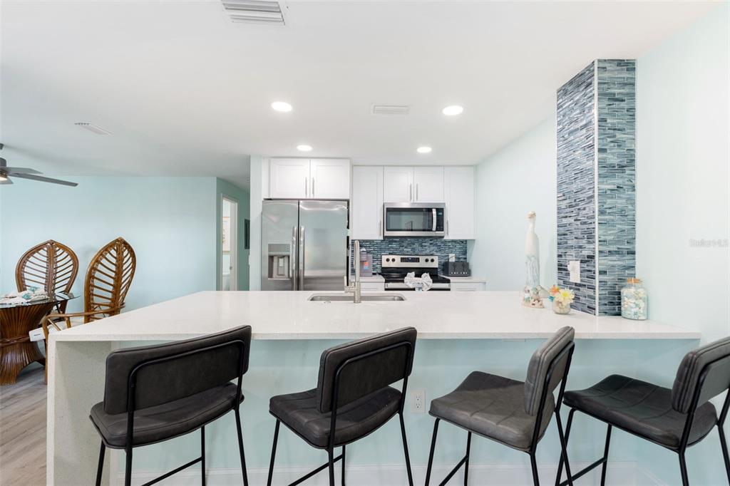 337 Rex Place, Unit G Madeira Beach, FL 33708 - Photo 9 of 40 a kitchen with stainless steel appliances a dining table and chairs