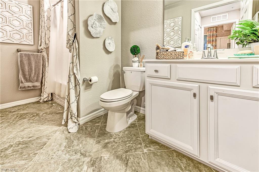 9572 Trevi Court, Unit 5015 Naples, FL 34113 - Photo 15 of 39 a bathroom with a toilet sink and mirror
