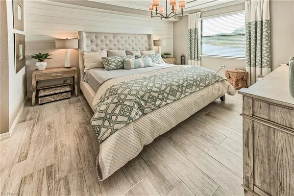 a bedroom with bed and a mirror on the dresser