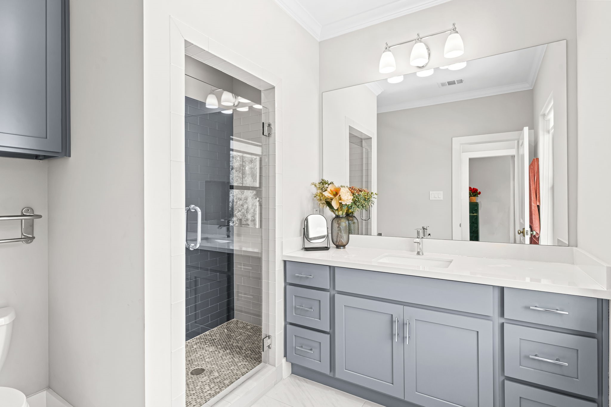 1013 Martin Street Houston, TX 77018 - Photo 32 of 46 Beautiful bath for secondary bedroom #2 w/frameless glass shower, subway tile surround, penny tile flooring, additional cabinetry storage, & abundant natural light.