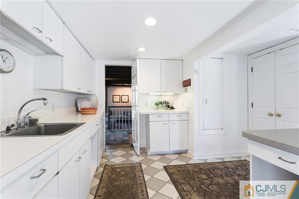109 Rolling Hill Road Skillman, NJ 08558 - Photo 11 of 25 a kitchen with white cabinets a sink stove and refrigerator