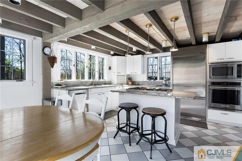 109 Rolling Hill Road Skillman, NJ 08558 - Photo 9 of 25 a kitchen with stainless steel appliances granite countertop a table chairs and a wooden floor