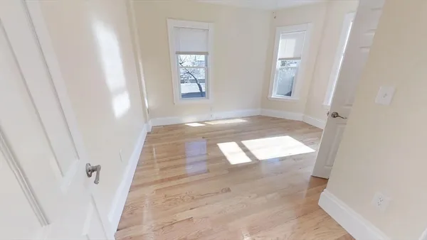 an entryway with wooden floor and windows