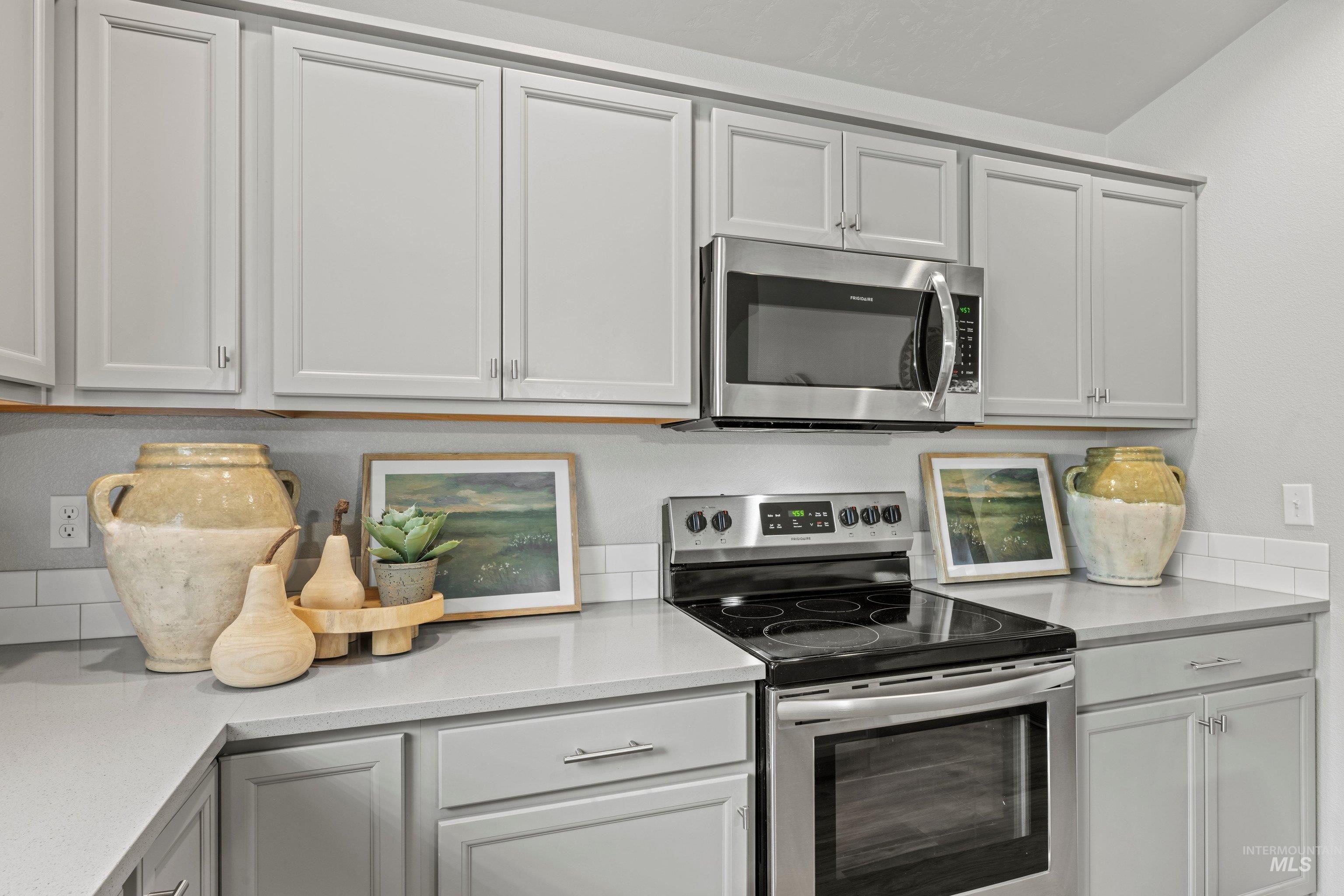 12744 West Fig Street Boise, ID 83713 - Photo 17 of 34 Modern kitchen featuring light gray cabinetry, stainless steel appliances, a subway tile backsplash, and light-toned countertops