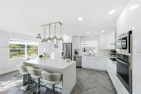 a kitchen with refrigerator cabinets dining table and chairs