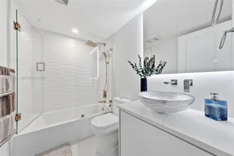 a bathroom with a granite countertop sink a toilet and shower