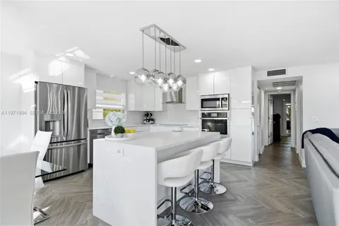a kitchen with kitchen island a refrigerator stove and microwave