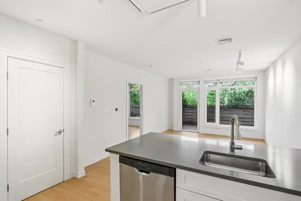 a kitchen with kitchen island a large window appliances and cabinets