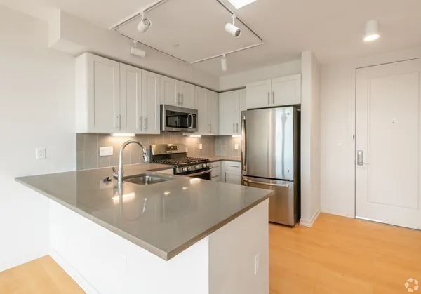 a kitchen with kitchen island a refrigerator a sink a stove a oven with a dining table and chairs