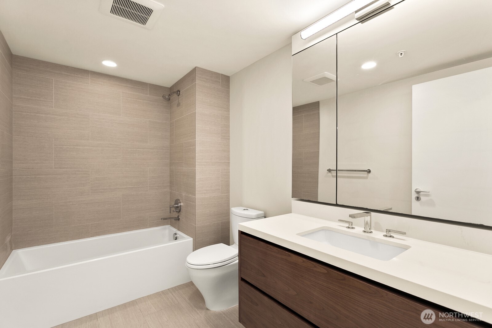 121 Stewart Street, Unit 1502 Seattle, WA 98101 - Photo 12 of 22 a bathroom with a bathtub shower sink vanity mirror and toilet