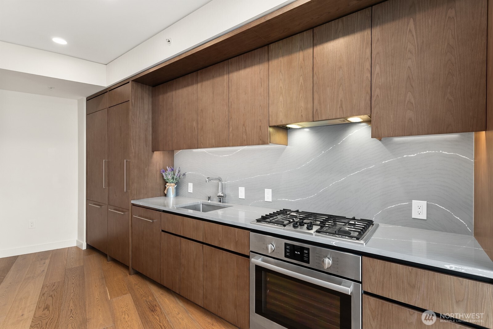 121 Stewart Street, Unit 1502 Seattle, WA 98101 - Photo 6 of 22 a kitchen with granite countertop a stove and a sink