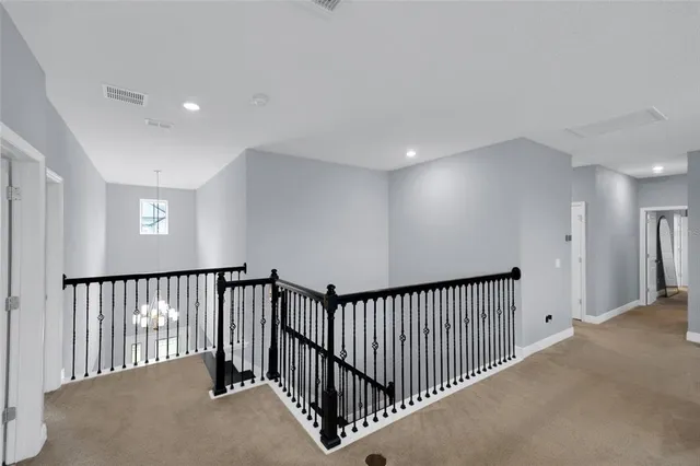 a view of a hallway with a chandelier and windows