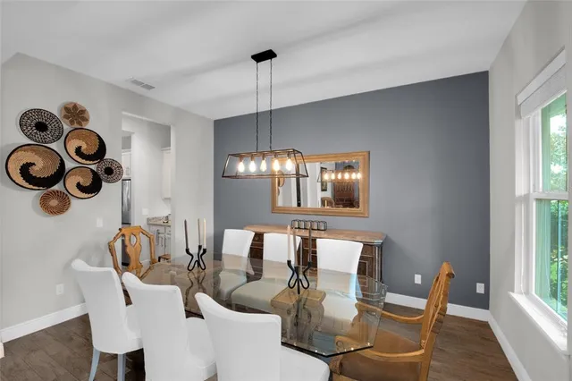 a dining room with furniture a chandelier and window