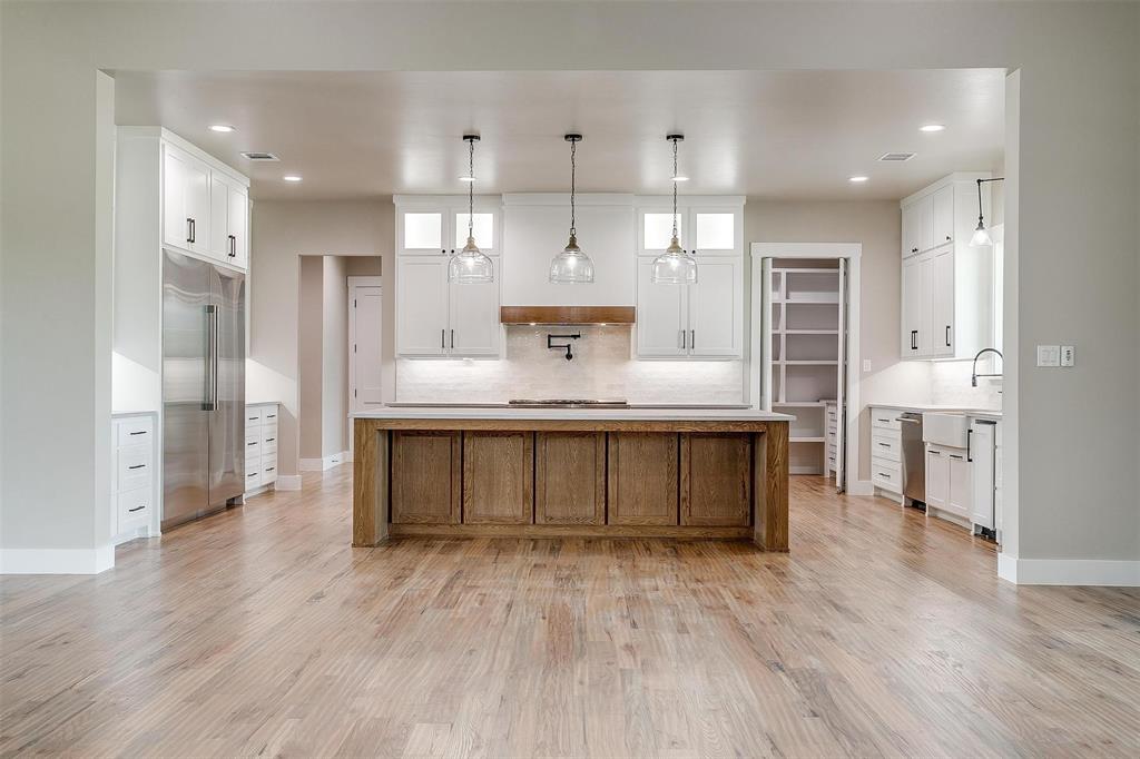 3019 Orchard Road Bowie, TX 76230 - Photo 15 of 40 a large kitchen with stainless steel appliances a large counter top a sink a refrigerator and a window