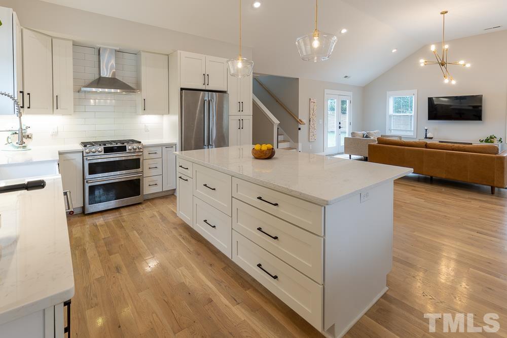 2200 Sheffield Road Raleigh, NC 27610 - Photo 19 of 44 a kitchen with stainless steel appliances kitchen island granite countertop a stove and a sink