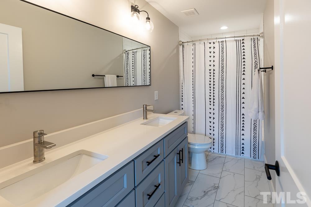 2200 Sheffield Road Raleigh, NC 27610 - Photo 30 of 44 a bathroom with a sink a toilet and shower