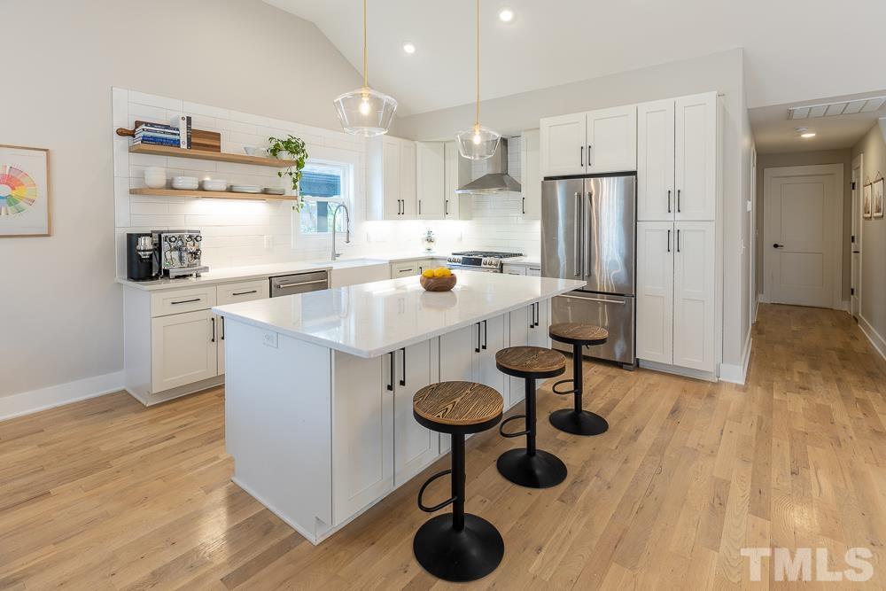 2200 Sheffield Road Raleigh, NC 27610 - Photo 5 of 44 a kitchen with stainless steel appliances granite countertop a sink a refrigerator and wooden floor