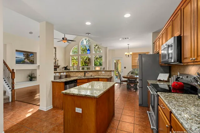a kitchen with stainless steel appliances granite countertop a sink stove and refrigerator