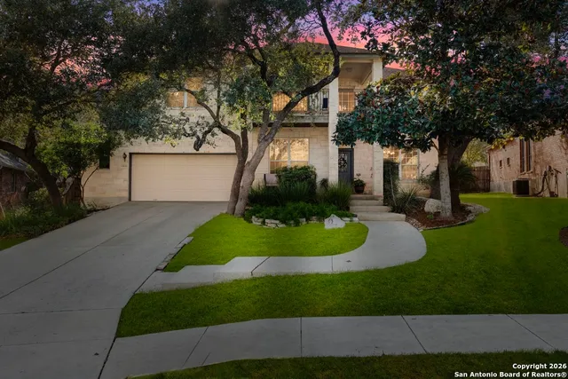 a front view of a house with a yard and trees