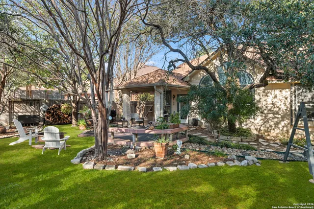 a view of a house with backyard and sitting area