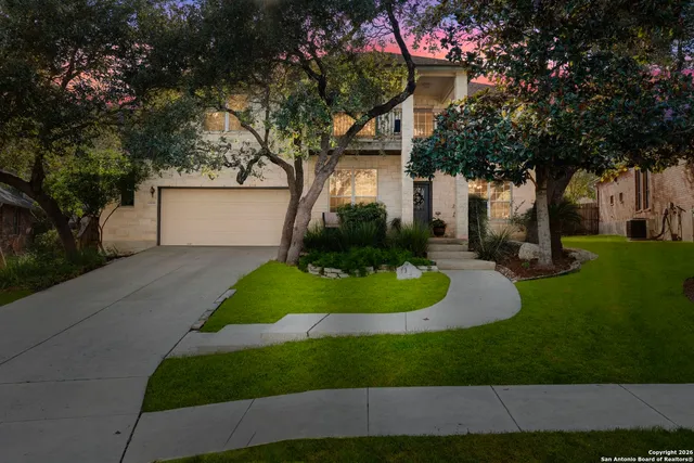 a front view of a house with a yard and trees