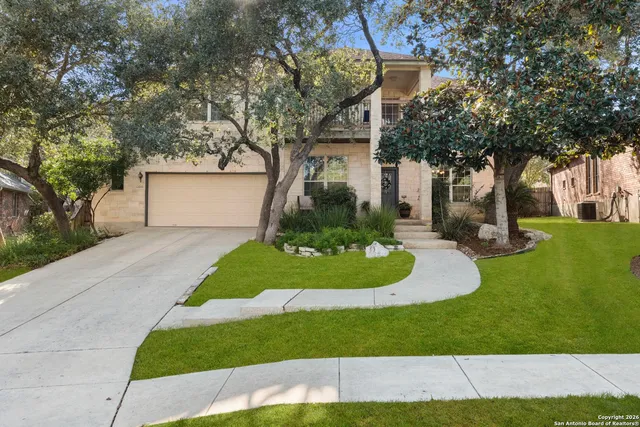 a front view of a house with a yard and trees