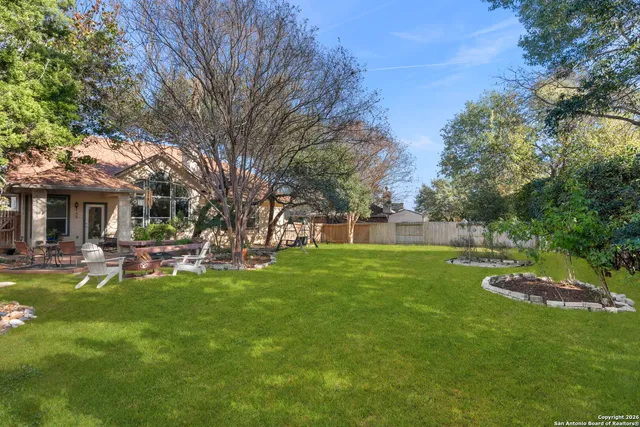 a view of a house with backyard and sitting area