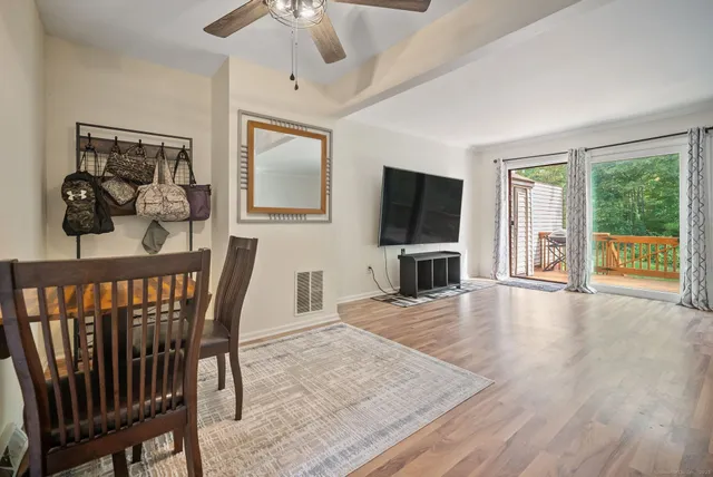 a view of a livingroom with furniture a flat screen tv and wooden floor