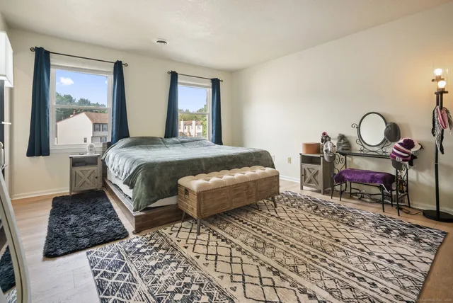 a bedroom with a bed a mirror and a window