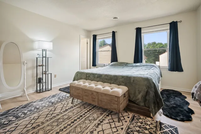 a bed sitting in a bedroom and mirror